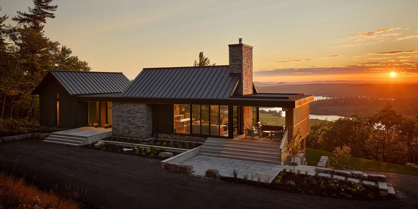 Casa Verde at dusk: stone, black steel and a wall of Alumalco glass